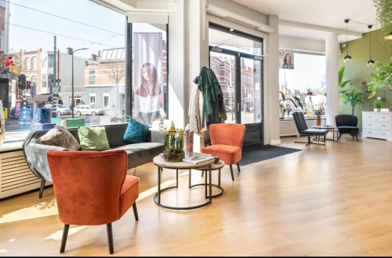 Lounge met oranje fauteuils in de kapsalon aan de Weimarstraat